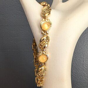 Gold tone link bracelet with pale yellow glass and gold crystal accents